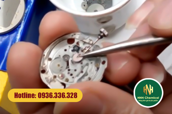 Thợ đồng hồ thao tác thủ công làm bề mặt linh kiện vi cơ học nhiễm vết bẩn dầu tay